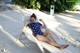 A woman in a polka dot swimsuit laying on a lounge chair.