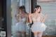 A woman in a white lingerie standing in front of a window.