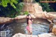 A woman in a pink bikini standing in a pool of water.