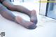 A woman in black pantyhose laying on a white table.