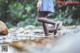 A woman in a plaid skirt is walking through a stream.