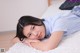 A young woman laying on a bed with her hand on her chin.