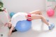 A woman laying on an exercise ball on the floor.