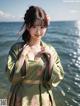 A woman in a green kimono standing in the water.