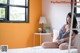 A woman sitting on a bed in a bedroom.